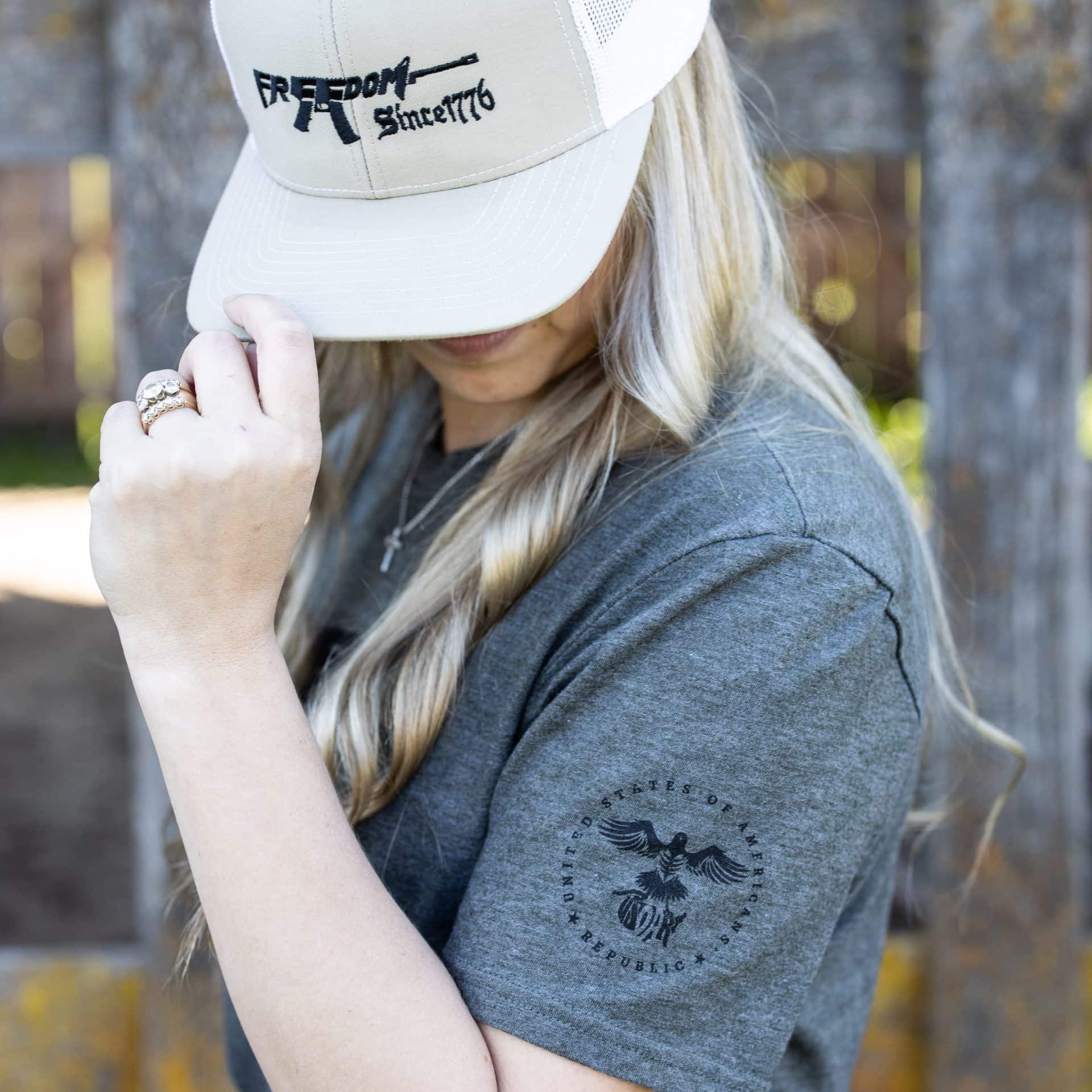 Woman wearing olive green Freedom Rifle T-shirt from United States of American's Republic USOAR